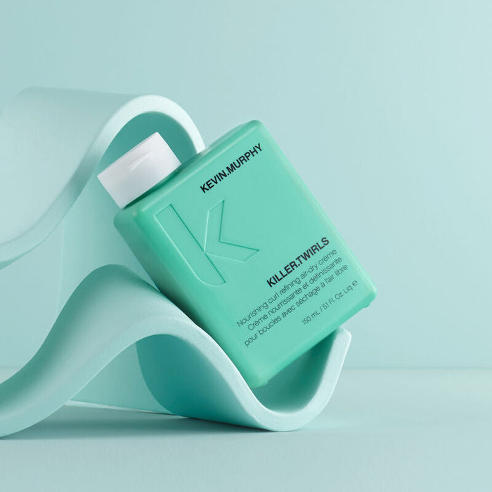 Kevin Murphy Killer Twirls styling product in a 150ml bottle in front of a blue geometric background.