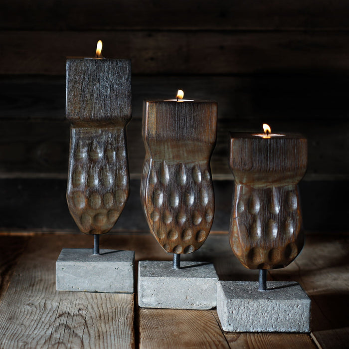 Set of 3 light different sized decorative wooden candle holder displayed on a wooden surface