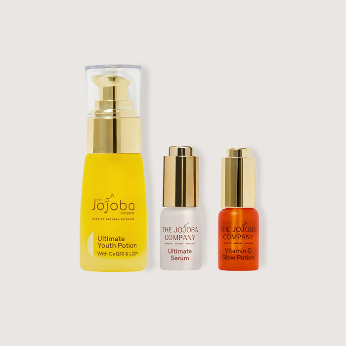 Three skincare bottles from The Jojoba Company on a light gray background