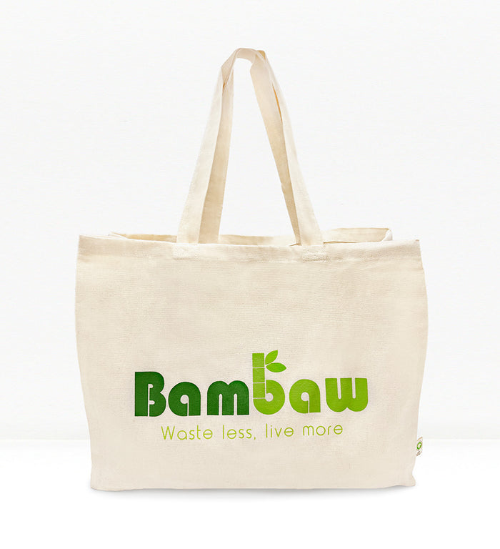 A beige cotton tote bag with the Bambaw brand logo printed in green. The bag has long handles and is displayed against a white background.