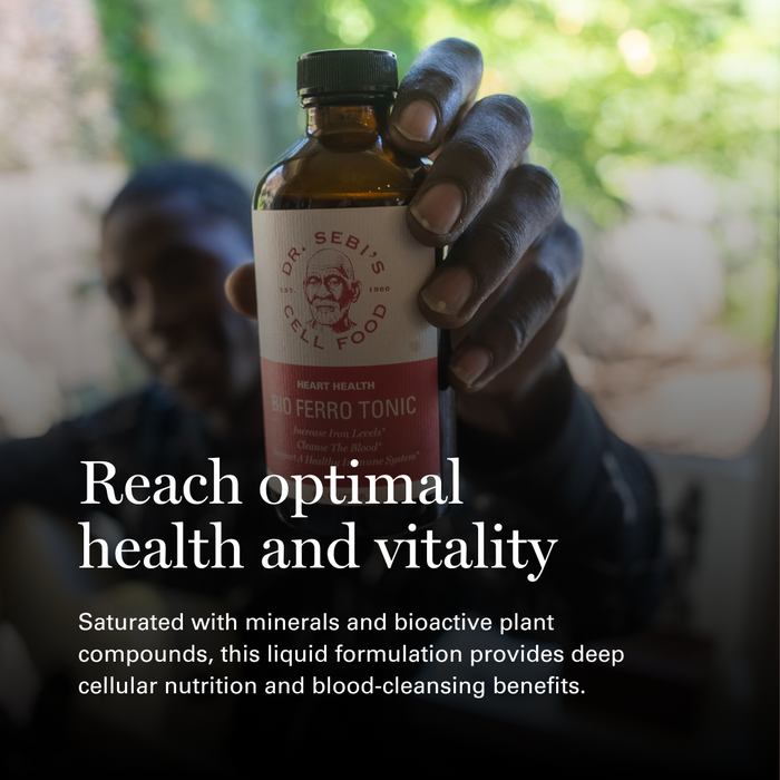 Hand holding Dr. Sebi's Bio Ferro Tonic bottle with heart health benefits text outdoors.