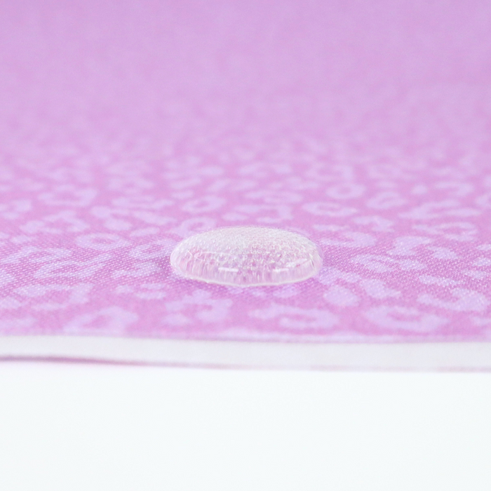 This printed WPC-Lite has a repeating light pink leopard print design with a deep saturated pink background. This photo shows a water drop on the fabric.