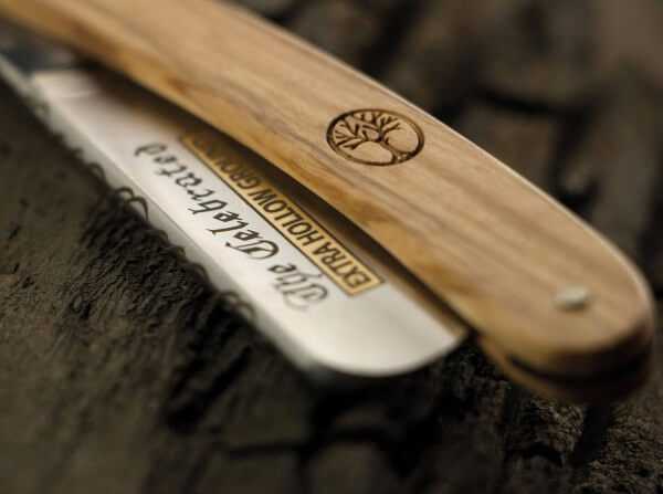 Close-up of Boker Celebrated Olive 5/8 Straight Razor with engraved blade and olive wood handle