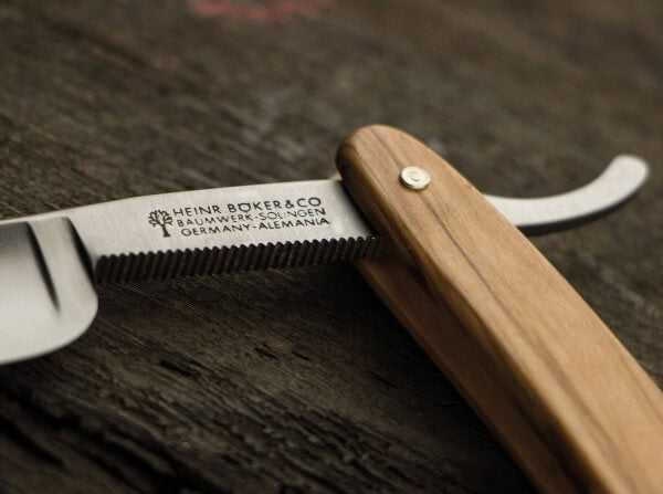 Boker straight razor with wooden handle and engraved blade for grooming and shaving