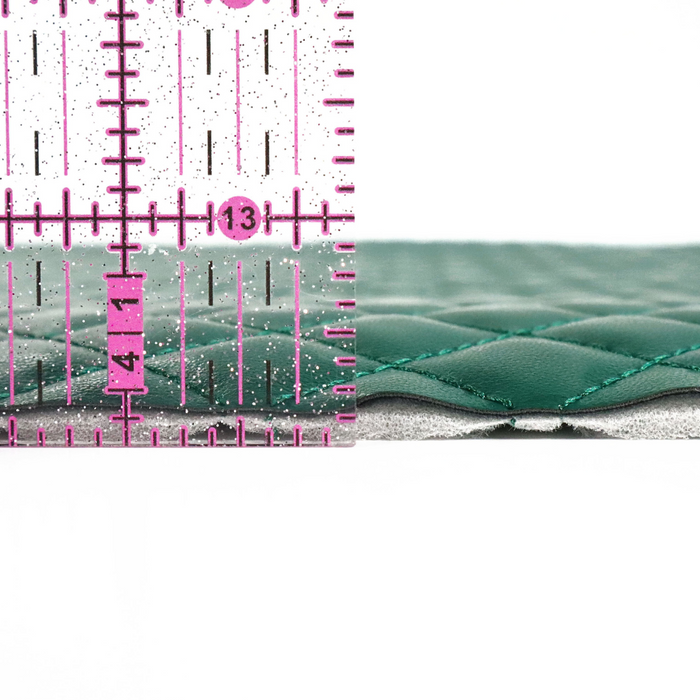This pre-quilted vinyl is a saturated and deep shade of green. This photo shows a ruler next to the side of the vinyl for width.