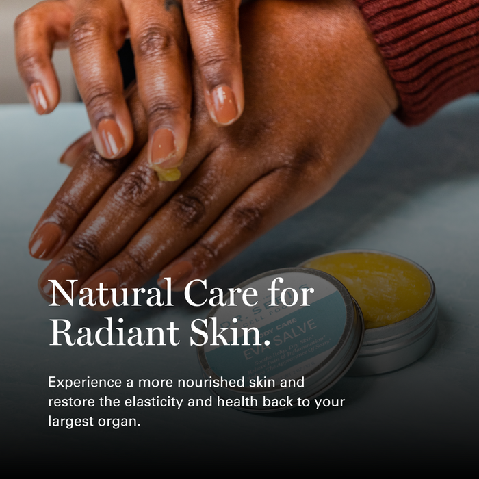 Woman's hands applying natural salve to skin with product containers displayed, promoting radiant skin care.