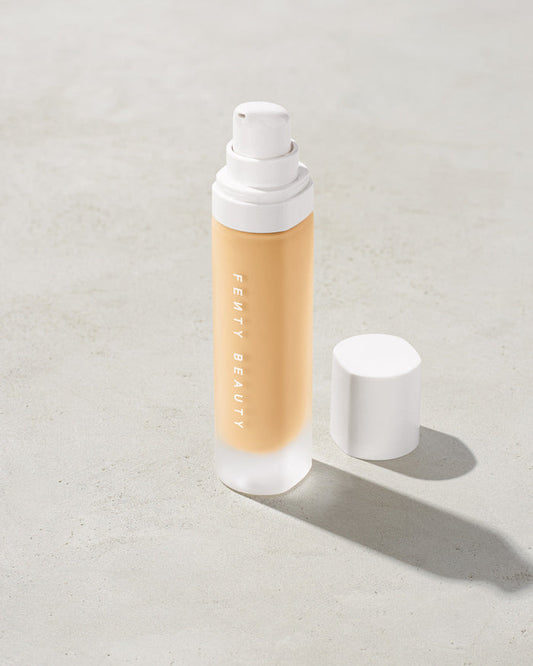 open bottle of Fenty Beauty Pro Filt'r Soft Matte Longwear Foundation with pump dispenser in shade #130 on concrete background