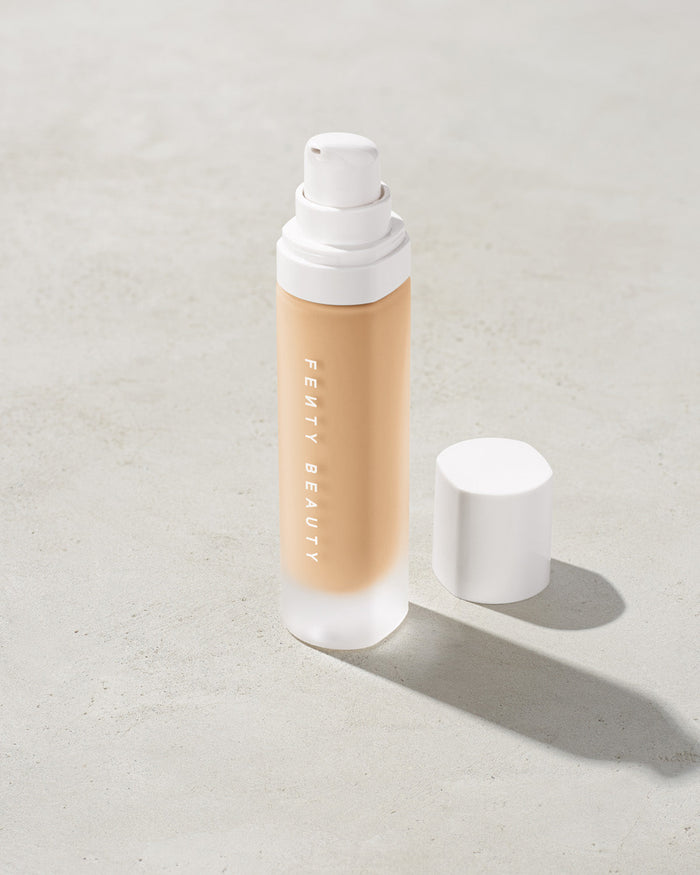 open bottle of Fenty Beauty Pro Filt'r Soft Matte Longwear Foundation with pump dispenser in shade #150 on concrete background