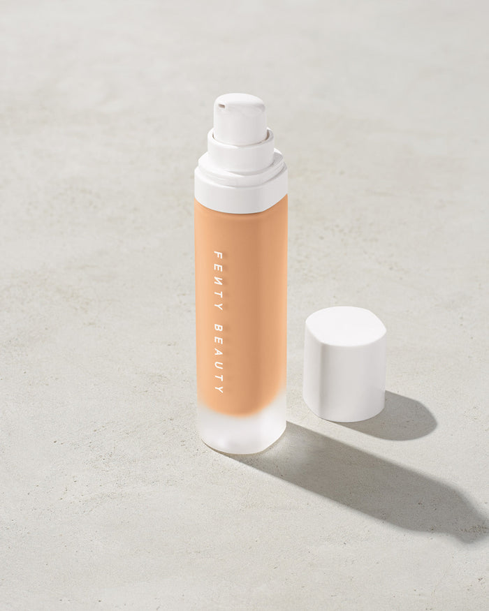 open bottle of Fenty Beauty Pro Filt'r Soft Matte Longwear Foundation with pump dispenser in shade #230 on concrete background