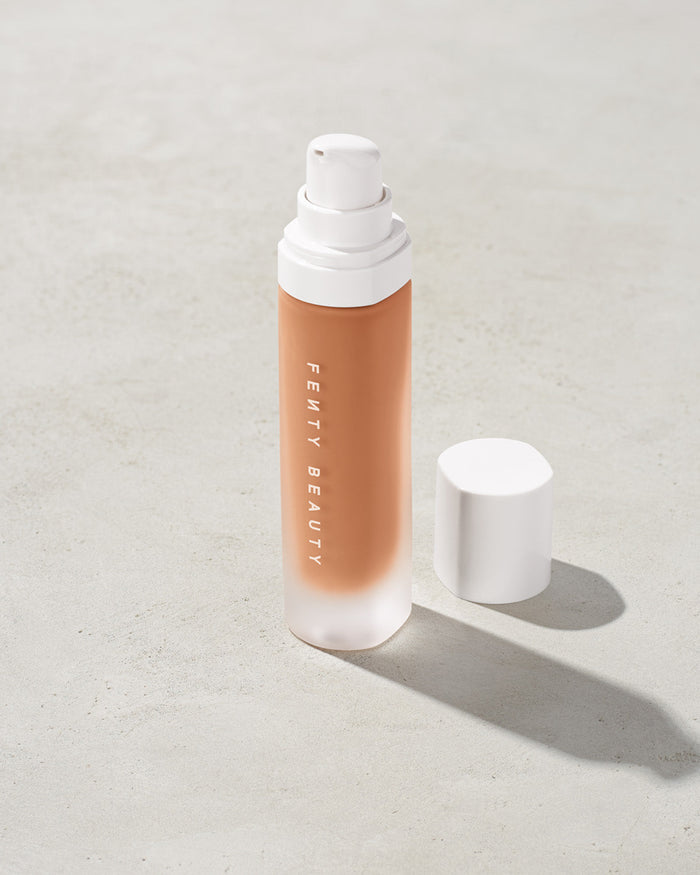 open bottle of Fenty Beauty Pro Filt'r Soft Matte Longwear Foundation with pump dispenser in shade 370 on concrete background
