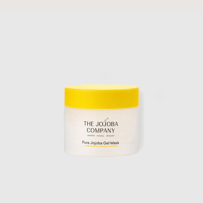A jar of The Jojoba Company Pure Jojoba Gel Mask with a bright yellow lid and a white jar, centered on a light gray background.