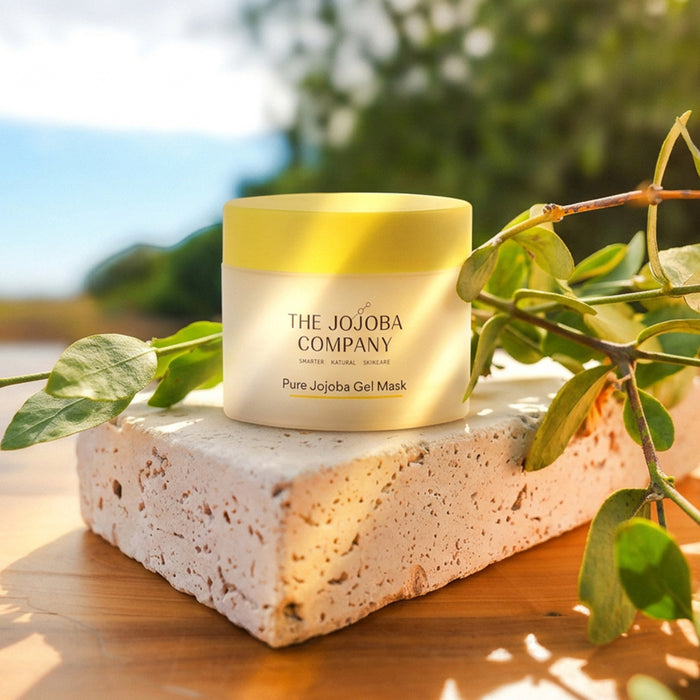 Jar of The Jojoba Company Pure Jojoba Gel Mask on a stone surface with greenery in the background