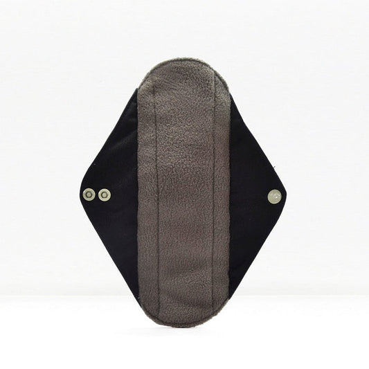 Single reusable panty liner with soft fleece interior and dark outer fabric with snap fasteners