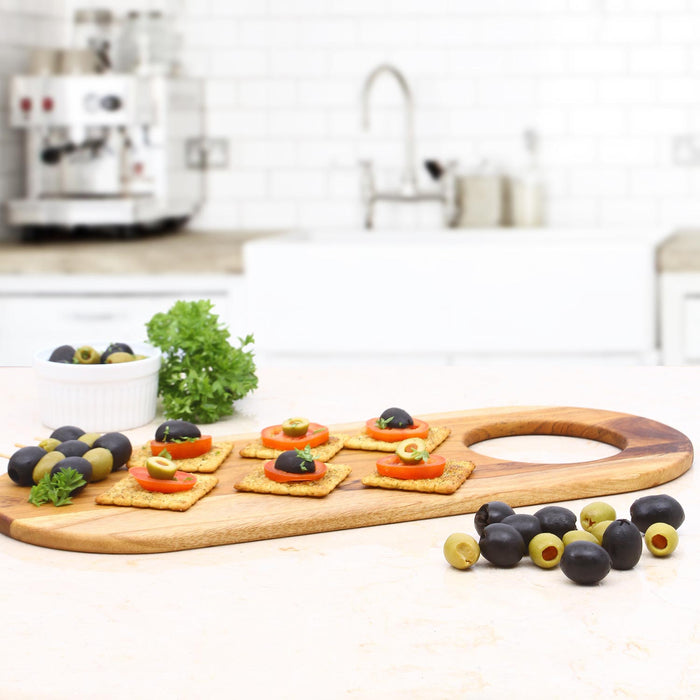 Rico & Plato teak serving board with charcuterie materials placed in a kitchen setting