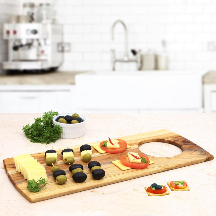 Rico & Plato teak serving board with an assortment with cheese and fruit displayed in a kitchen setting