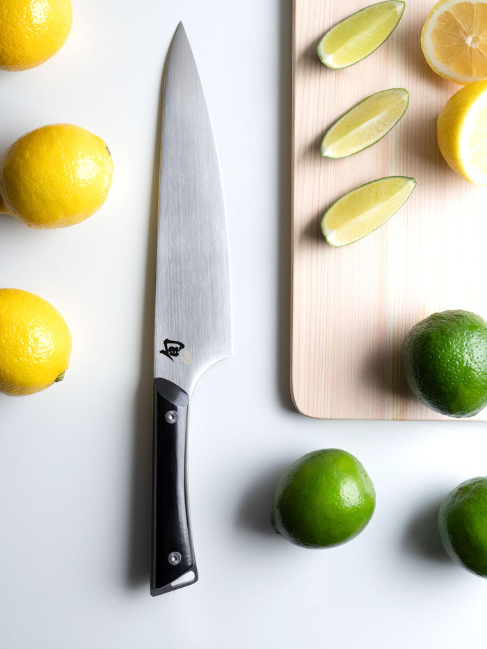 8 inch Shun Chef knife on a white countertop next to lemons and limes