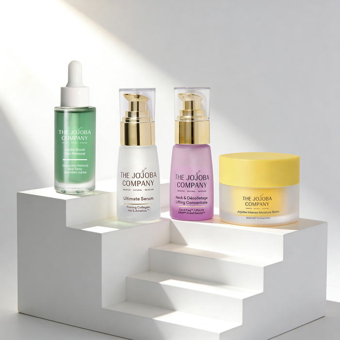 Skincare products from The Jojoba Company on a white geometric shelf