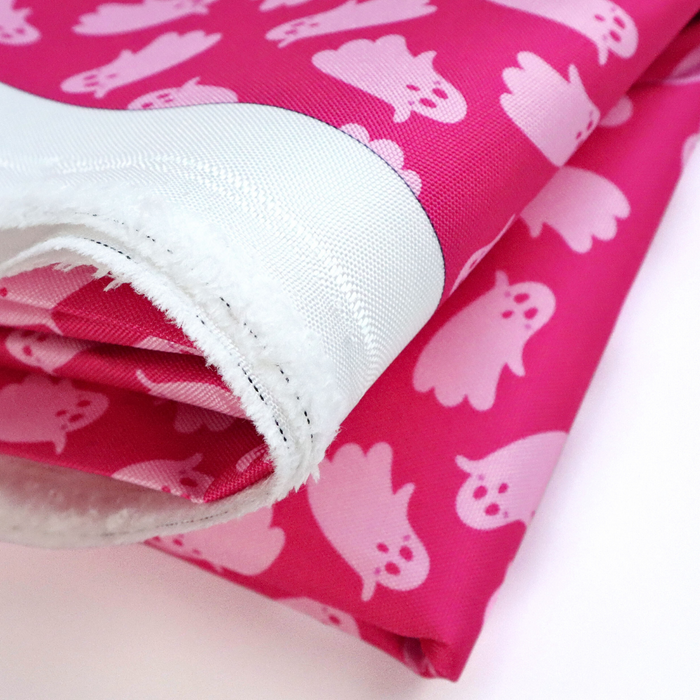This printed WPC-Lite has ghosts that are featured in light pink on top of a deeper pink background. This photo shows the fabric folded.
