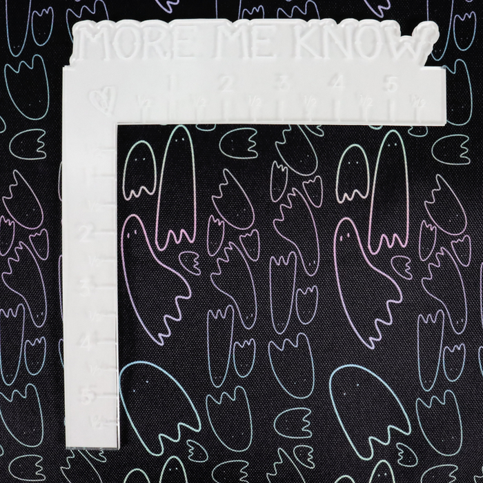 This printed WPC has pastel rainbow ghost outlines in different sizes on a black background. This photo shows a white L shaped ruler for scale.